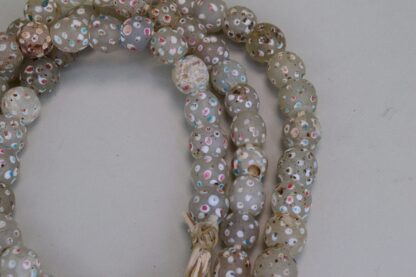 Antique Skunk Trade Beads are white with pink and turquoise dots. this lot on a strand.