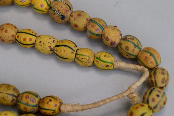 Antique Venetian Trade Beads - Fiber Strands of Venetian Mustard trade beads with green lines and red dots designs on a strand. Limited Quantities.