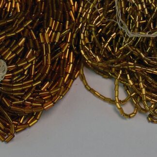 These Gold Iridescent Bugle Beads are approximately 4mm x 2mm and come a in 21 oz package. Crafters often use them for creating beaded necklaces. One of a Kind!