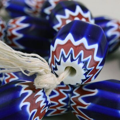 Large Glass Chevron Beads , are blue, white and rd. they are oblong. these beads come on a string.