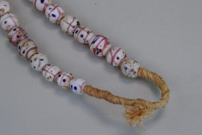 These Venetian Trade Beads are on a Fiber Strands with white trade beads with pink lines and Blue dots. . Limited Quantities.