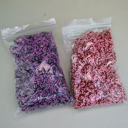 11/0 Seed Bead comes in a 16 ounce package. Colors are lined pink, light pink, fuchsia, trans red and royal blue in a tubular shape. On of a Kind.