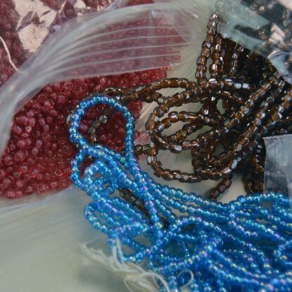 These 9/0 Seed Bead Lot are a must have! They come in a 9 ounce bag with Cuts Iris light Blue, and Brown , Also a 10/0 raspberry