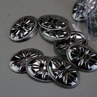 Metal Conchos Oval come in a  1.75 Inch Long x 1.5" Oval Stamped Metal Conchos with a flower design. 110 Pieces in this lot. One of a Kind !