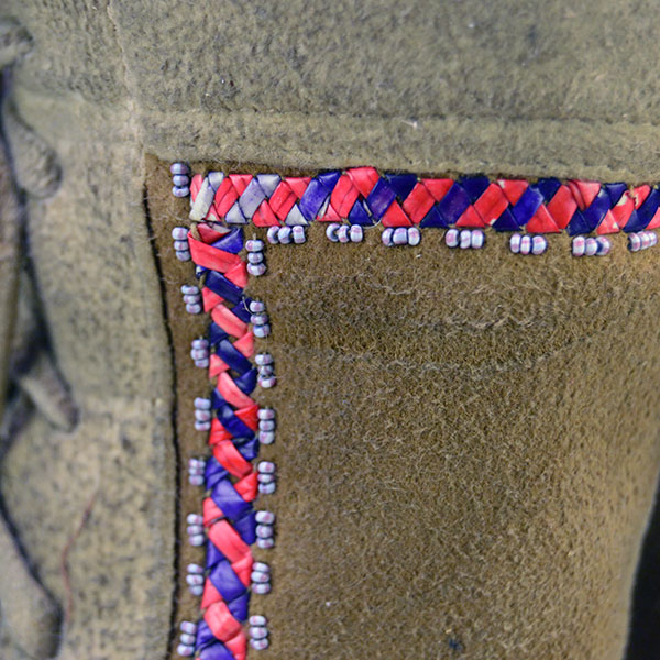 These Cree-style high-top moccasins are handcrafted from smoked moosehide leather, featuring soft soles and adorned with vibrant floral beadwork , and quill work that reflects traditional woodland design Quillwork detail