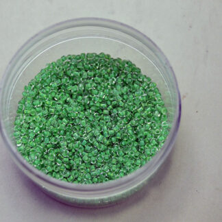 These Lined Green Seed Beads showcase a transparent exterior and a vibrant color-lined core. Sold in 1/2 kilo lot, and are a size 12/0. One of a Kind