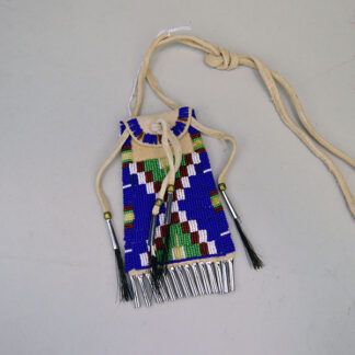 Crafted from supple brain-tanned deerskin, this strike-a-lite bag features intricate lazy stitch beadwork in royal blue seed beads, accented with shimmering tine cones that lend both movement and tradition to its design.
