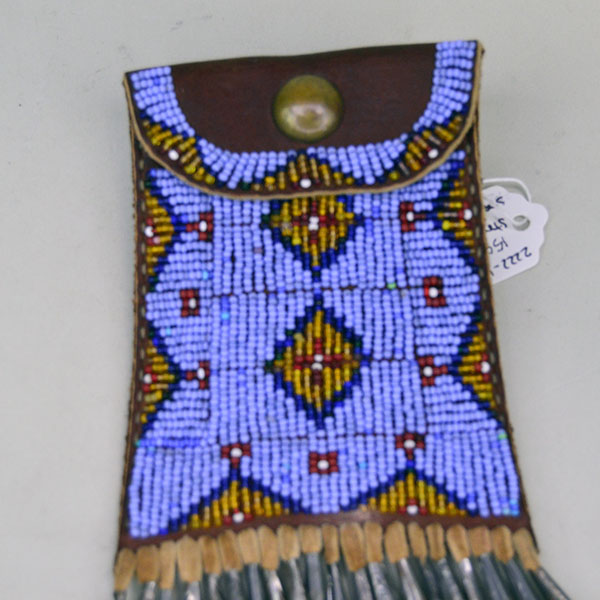 This fully beaded Periwinkle Strike-a-Lite bag features hand-stitched geometric beadwork accented with brass beads and tin cones, while the up-close front view highlights the intricate detailing of the beadwork.