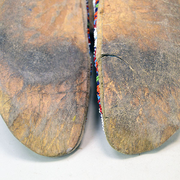 Pictured here, the moccasins showcase soles made of rawhide, highlighting their traditional craftsmanship.
