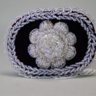 Front view of large beaded barrette with white flower.