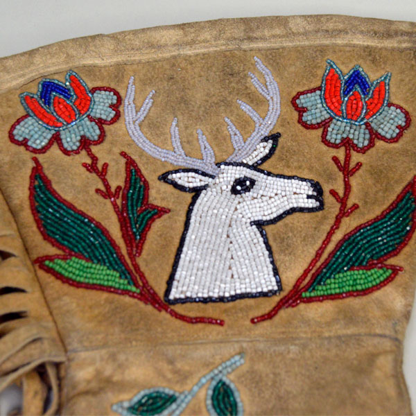 Beaded leather gauntlets with a floral and deer motif close up of beadwork.