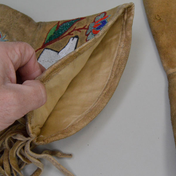 Beaded leather gauntlets with a floral and deer motif inside view.