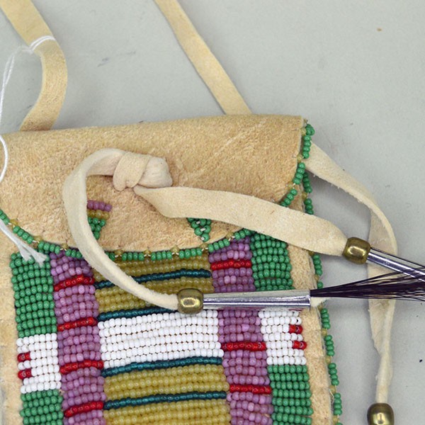 Close up front view of a green Arapaho style strike a lite bag showing beadwork.