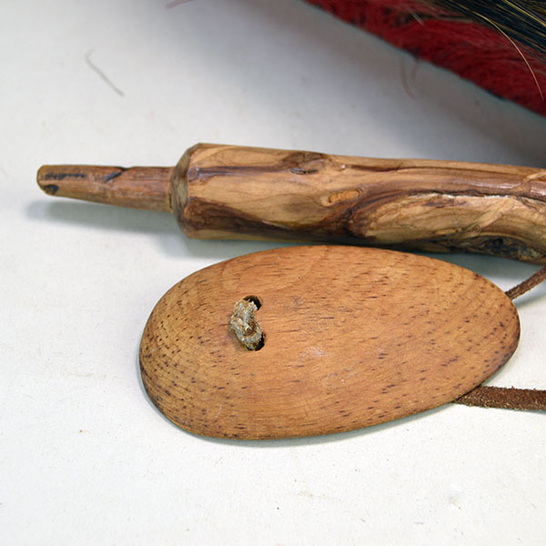 Wooden roach spreader that comes with antique hair base roach.