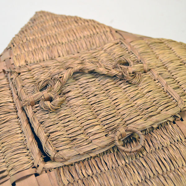 Pictured here is a Passamaquoddy handkerchief basket featuring a finely crafted handled lid, skillfully woven from sweetgrass and ash.