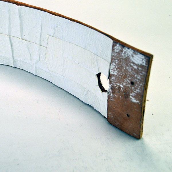 This vintage handcrafted belt, beaded in blue with a geometric design, is pictured here showing the white tape applied to the inside