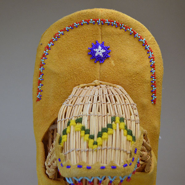 This Vintage Cradleboard- Doll is ready for display in your home! It is in remarkably great condition for its age made in 1988 in Reno Nevada. Picture here is the beaded design above the visor and the design on the visor.