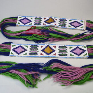 These Garters- Loomwork Panel beaded feature a vibrant loomwork panel accented with Blue, Green, and Rose yarn tassels. One of a kind.