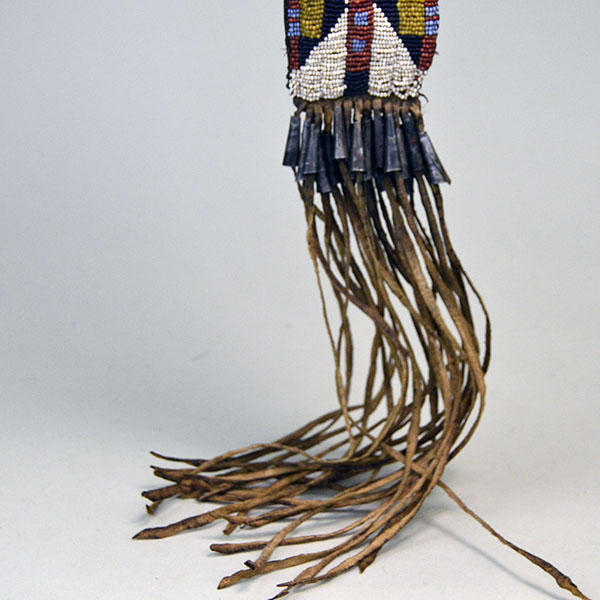 This fully beaded Northern Plains style Knife Sheath- Squared Ended will make a great addition to your collection! One of a Kind. Pictured here is the bottom show casing the bead work, the tin cones and the tassels.
