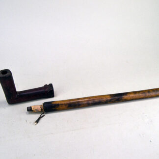 This hand‑carved Pipe- Catlinite is presented with its original wooden stem. The piece measures 20 inches in total length. one of a kind.