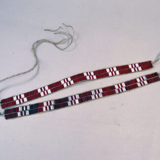 These Wampum Garters- 2 Row are constructed with white and red glass wampum beads. Each garter measures approximately 12 inches by 0.75 inches.