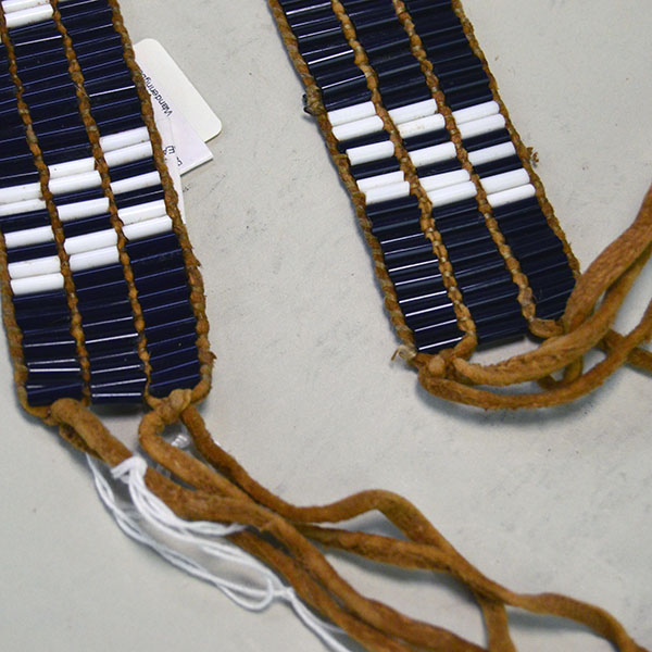 This striking 46.5‑inch Glass Wampum Strap/Belt-3 Row features three rows of white and blue 3×8mm glass beads, arranged in a classic pattern. on of a kind. pictures shows the ties at the end next to the bead work.