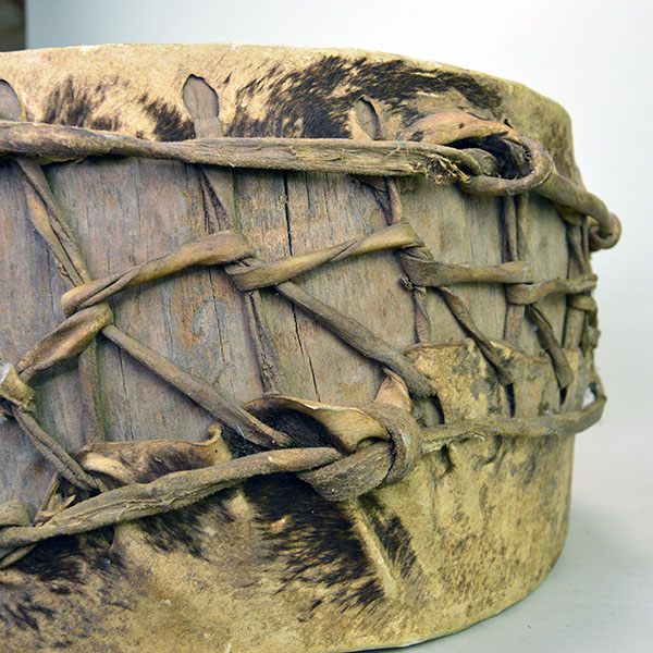 Old Log Drum, 16" x 7.5". Crafted from a single old log, this pre‑1900 drum is a rare survivor and remains in impressive condition for its age. Pictured here is the lacing and some of the brown hair.