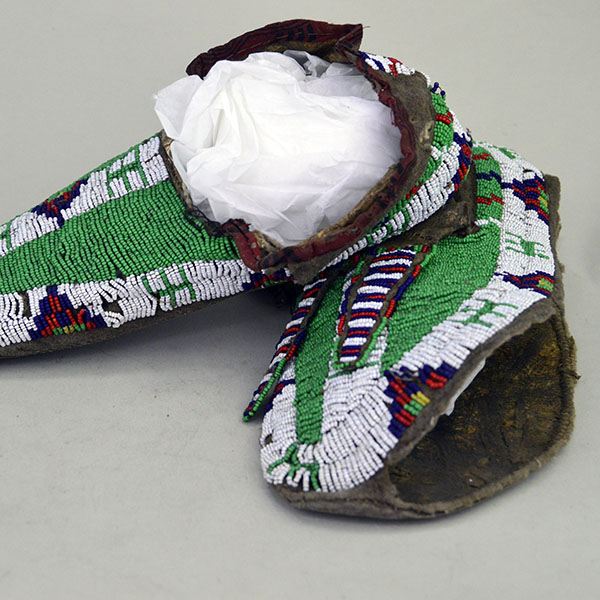 Beaded Men's Vintage Moccasins showing hole in leather.