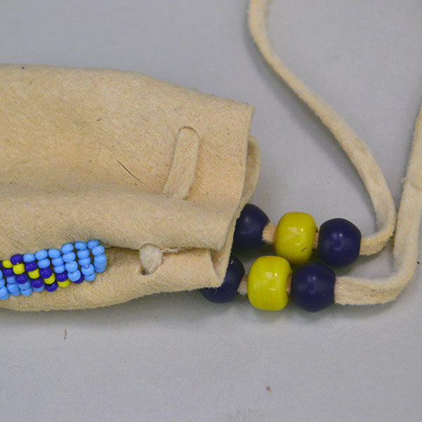 charming smoke‑colored deerskin Neck Bag- Beaded Edge. 13/0 cut Seed Beads in navy blue, yellow, and light blue. One of a Kind. pictured here is the crow beads and the top of the neck bag.