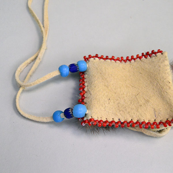 Neck Bag- Otter Fur Flap features beautifully soft smoke‑colored deerskin leather. edge‑beaded the sides with white‑center red seed beads. one of a kind. pictured here is the bead work on the sides and the crow beads and chevron beads.