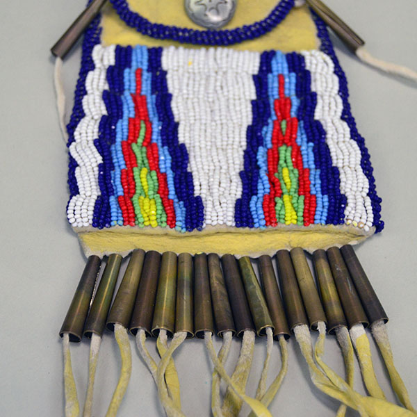 Strike-a-lite beaded bag with geometric design, metal cones and leather fringe.