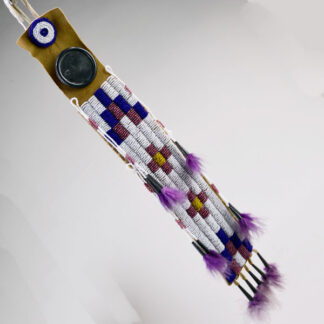 Hair ornament purple fluffs on brain tan leather with geometric beadwork.