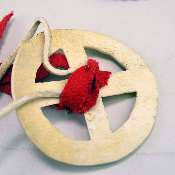 group lot offers a striking mix of accessories. beaded rosette star, bone cutout pendant, stamped brass Kokopelli, and stamped German silver concho. pictured here is the bone cutout medicine wheel pendant.