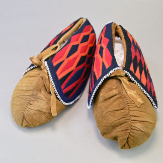 Women’s center‑seam Moccasins- Trimmed Ribbon Cuffs. maker used a darker Braintanned deerskin. approximately 8.5 inches long, 3.5 inches wide.