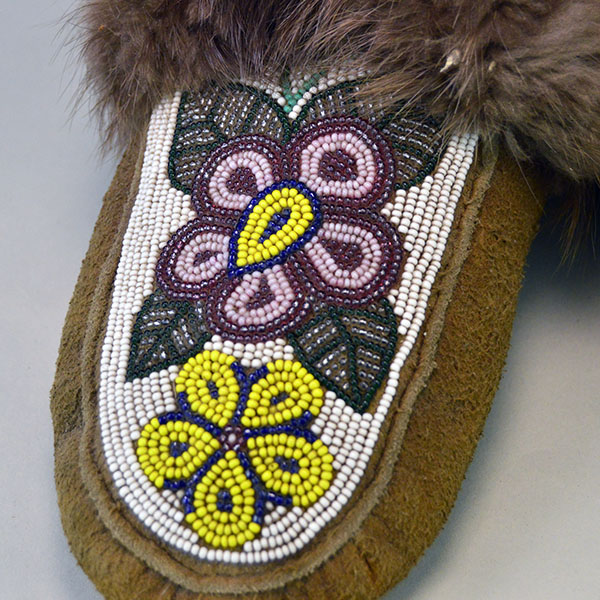 hand‑crafted Cree smoked‑moosehide moccasins showcase classic Cree styling. vibrant floral beadwork design adorns the vamp. beaver fur to the cuffs. pictured here is the floral beaded vamp.