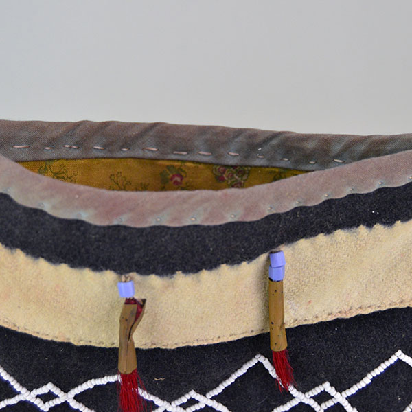Bag- Wool Shoulder Beaded features beadwork and hand‑sewn ribbon edging. measures approx. 8.5" tall x 9" wide, shoulder strap measures 29" long. The top of the bag showing the inside floral fabric lining.