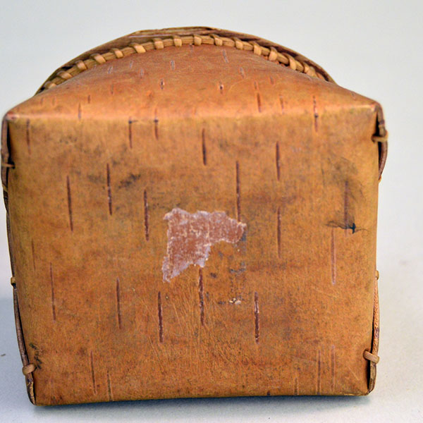 1950's tiny Basket- Birchbark with Lid. artist secured the container with traditional spruce‑root stitching. approx. 2.75" tall x 3.5" long. one of a kind. the bottom.