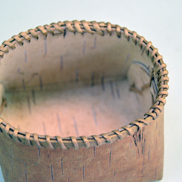 1950's tiny Basket- Birchbark with Lid. artist secured the container with traditional spruce‑root stitching. approx. 2.75" tall x 3.5" long. one of a kind. inside the contanier.