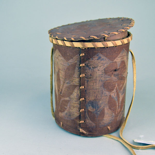 Floral‑Etched Birchbark Basket with Lid Container features Floral etchings around the container and the cover. approx. 9" tall x 8" in diameter. The seam of the basket. stitched with spruce root.