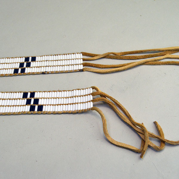 Belt Strap- Wampum 3 Row features a repeating geometric pattern. glass Wampum Beads in White and Cobalt Blue. approx. 43 Inches long x 1.25 inches wide. the smoked color deerskin lacing.