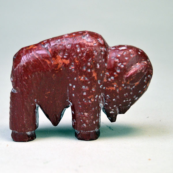 Hand‑carved Catlinite Bison, approximately 3.25 inches long and 2.5 inches tall. initials “BE” on the underside, and Indian Made Pipestone Craft” sticker.