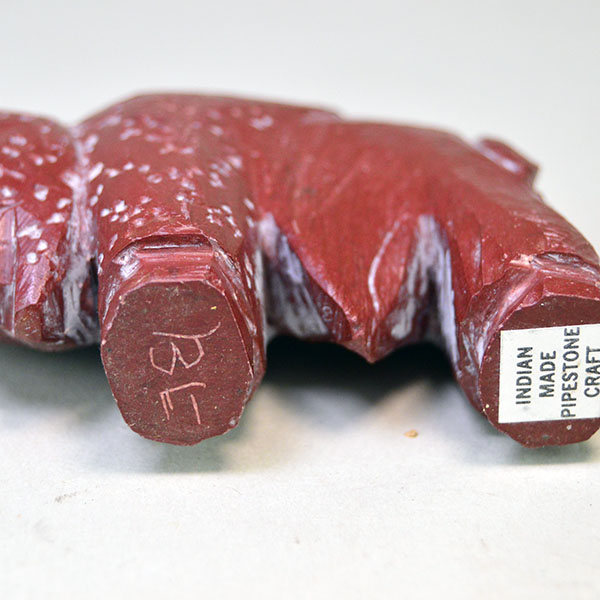 Hand‑carved Catlinite Bison, approximately 3.25 inches long and 2.5 inches tall. initials “BE” on the underside, and Indian Made Pipestone Craft” sticker. the bottom.