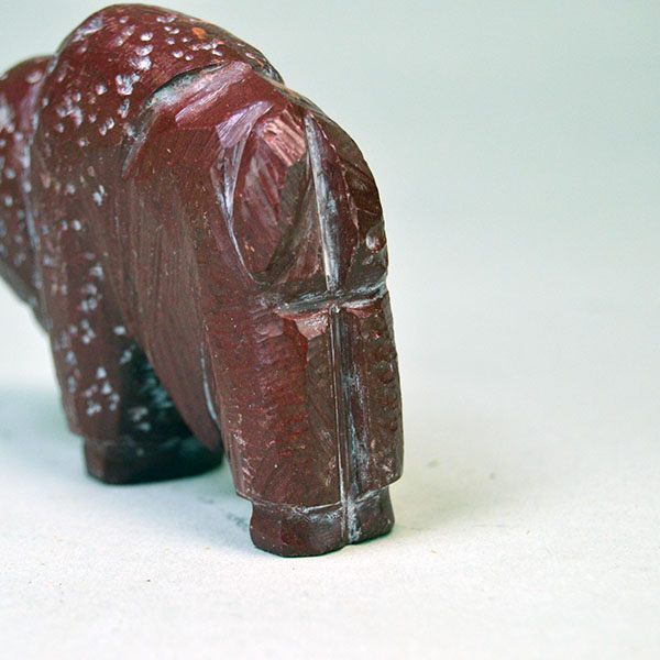 Hand‑carved Catlinite Bison, approximately 3.25 inches long and 2.5 inches tall. initials “BE” on the underside, and Indian Made Pipestone Craft” sticker. The back