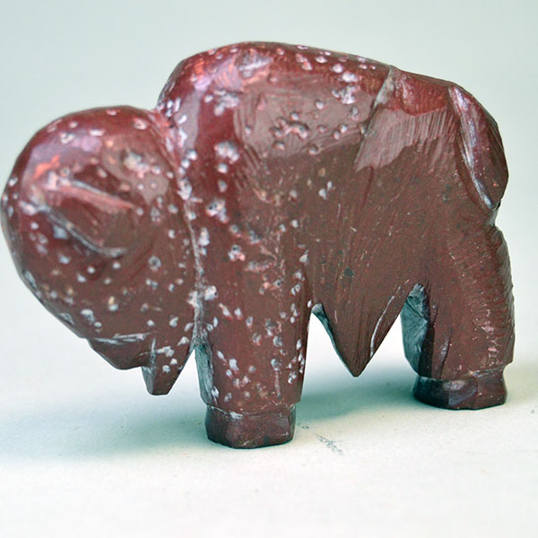 Hand‑carved Catlinite Bison, approximately 3.25 inches long and 2.5 inches tall. initials “BE” on the underside, and Indian Made Pipestone Craft” sticker. The other side.