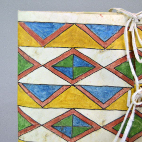 Add this brightly Parfleche- Painted Rawhide Container to your collection! The container measures approx. 11" wide x 15" long. One of a Kind. A up close of the geometric design on the front.