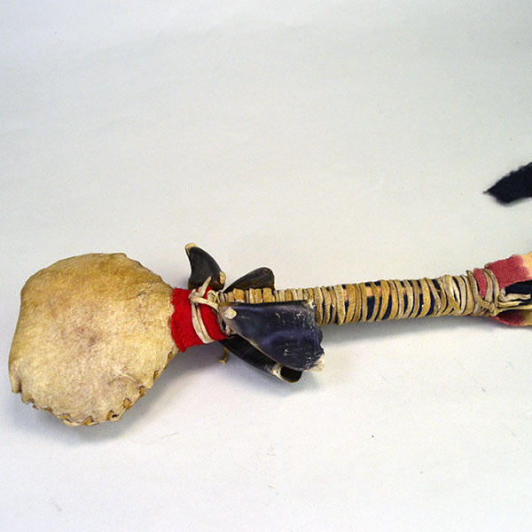 Contemporary Rattle- Rawhide features four deer toes and a wooden handle wrapped in wool and tied with deerskin leather lacing. Approx. 11" x 4". The whole rattle .