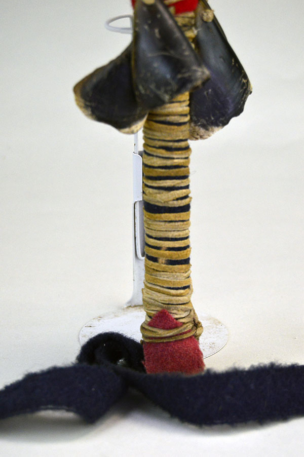 Contemporary Rattle- Rawhide features four deer toes and a wooden handle wrapped in wool and tied with deerskin leather lacing. Approx. 11" x 4". pictured here is the leather lacing on the handle.