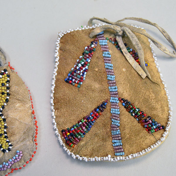 Bag- Beaded Braintanned Pair, dating to the 1940s, showcases two distinct expressions of hand‑worked artistry. Approx. 4.25" x 3.5", and 3" x 3.5". The beaded bag with the design on different sizes and colors.
