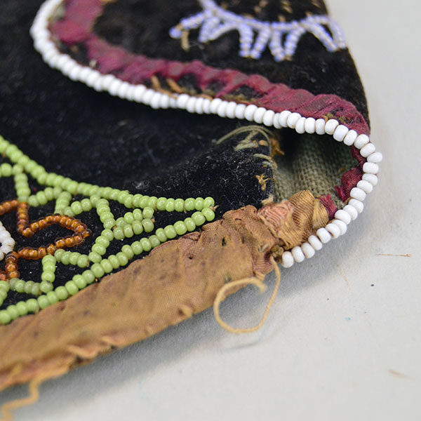 antique, late 1800s Mi'kmaq-style bag, measures approx. 4" x 4". It features a design using 16/0 seed beads intricately stitched onto black velvet. some of the edging beads missing.
