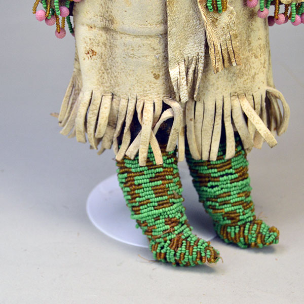 This antique Doll- Northern Plains Style offers exceptional handmade detail and strong visual presence. She stands approx. 14 inches tall. One of a Kind. The skirt and the beaded moccasins.